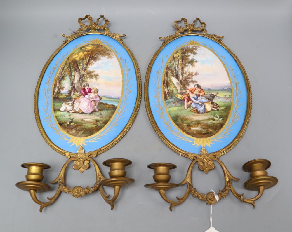 A pair of gilt brass two branch wall sconces with oval Sevres style plaques, length 40cm